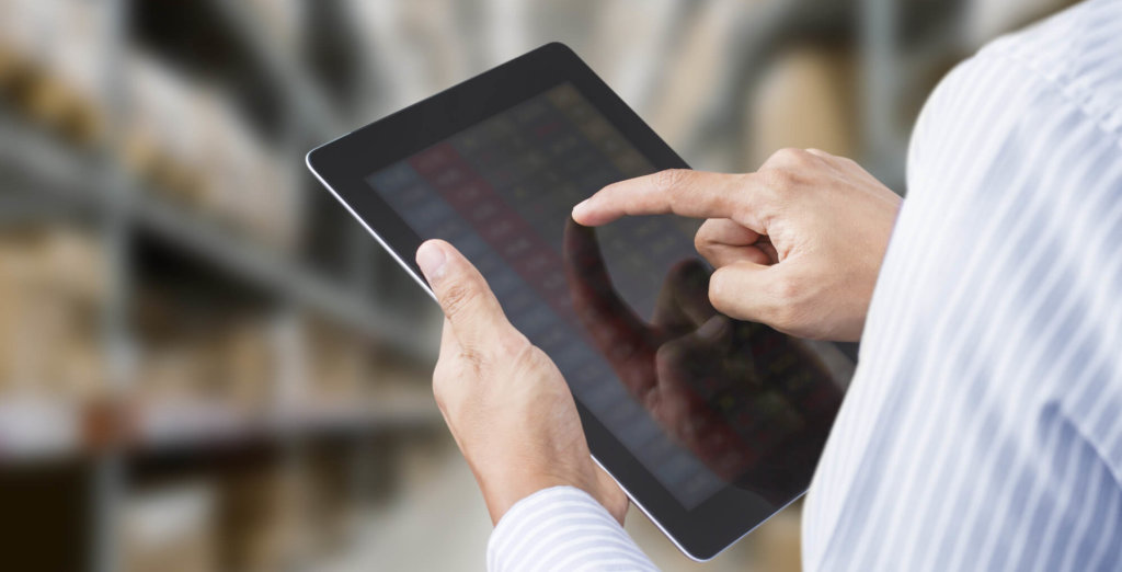 Businessman checking inventory in stock room on tablet